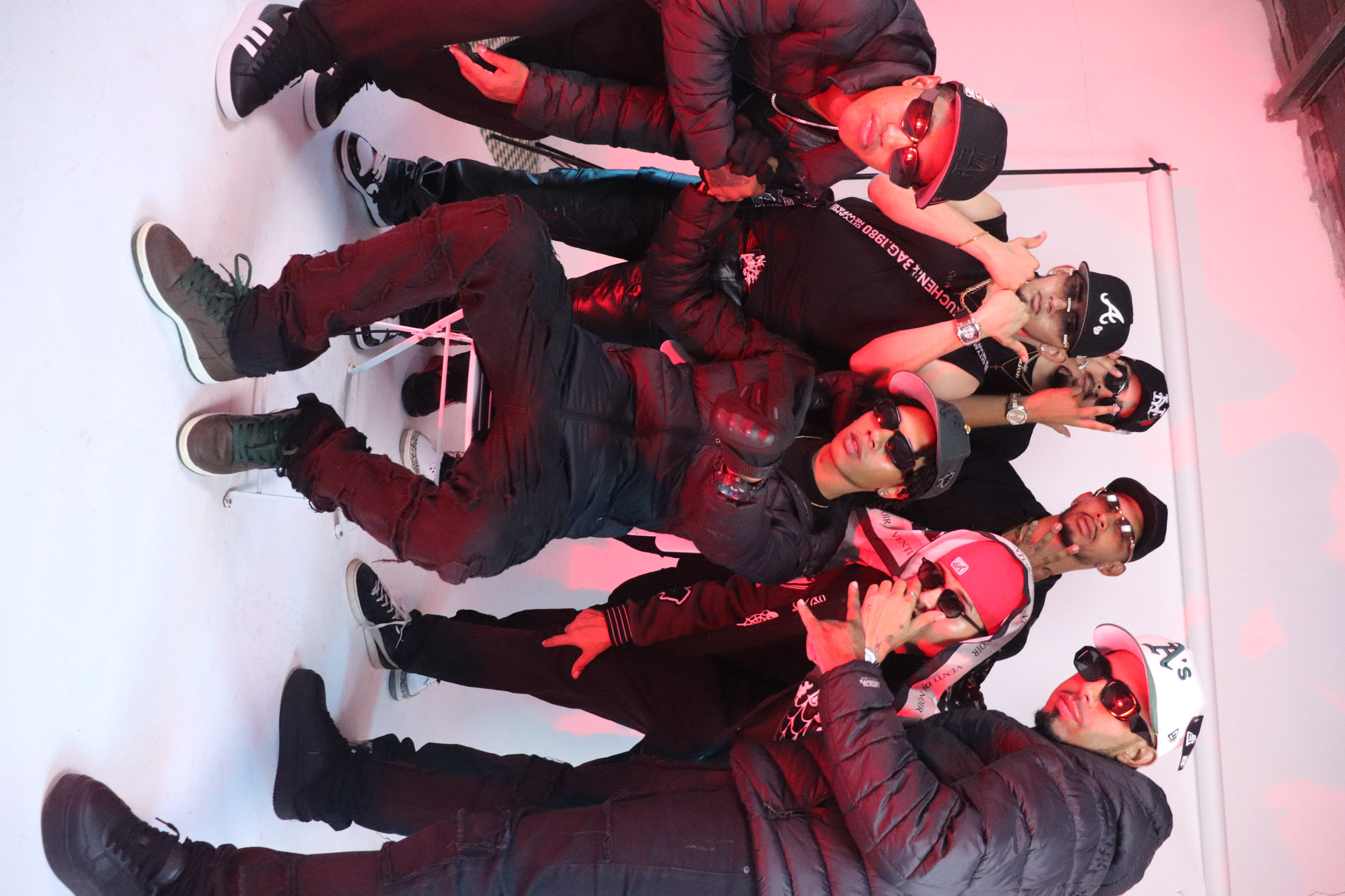 Una vibrante toma detrás de escena de artistas musicales y su equipo posando antes de filmar su video musical